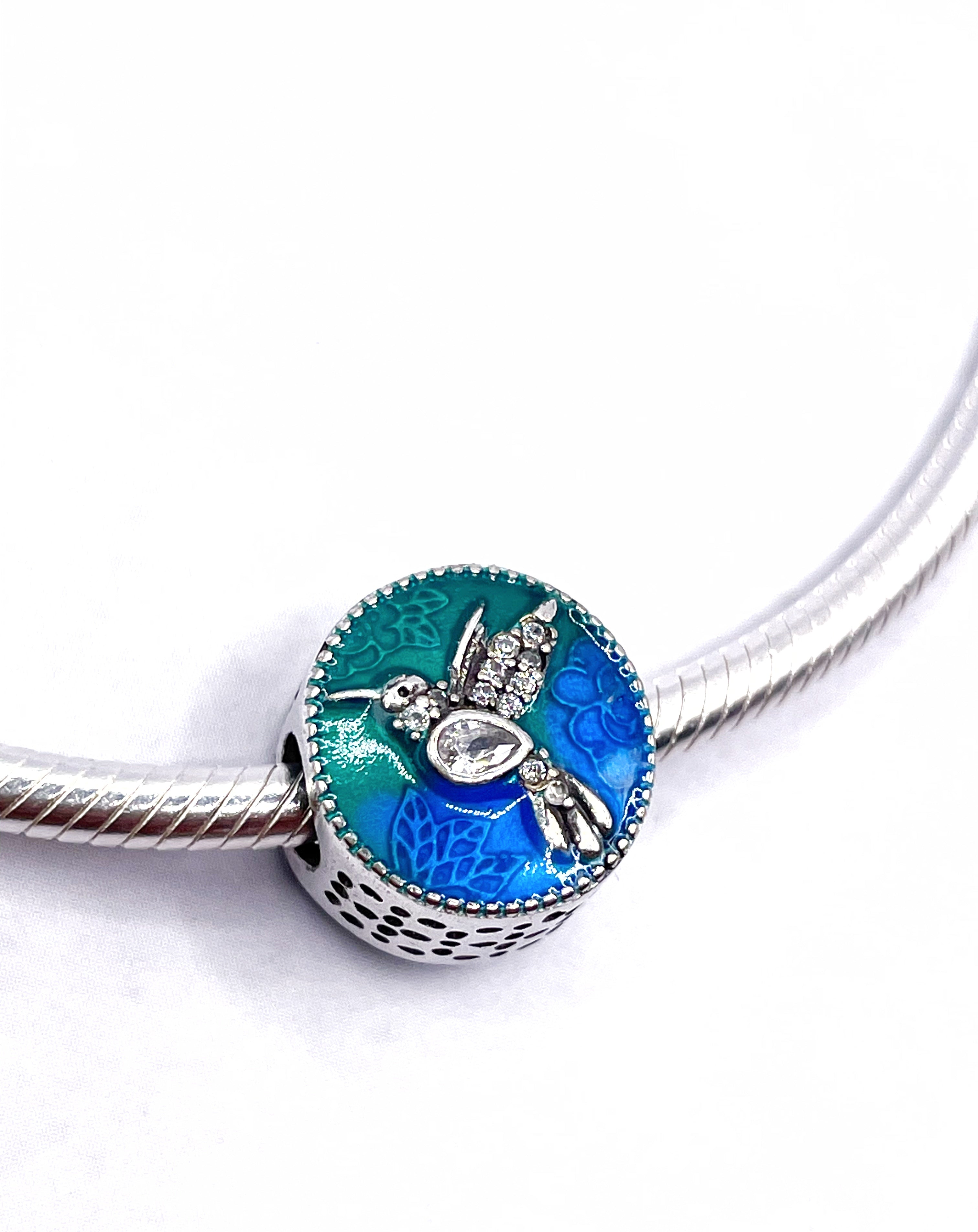 Charm Colibrí con circonias blancas y fondo verde y azul