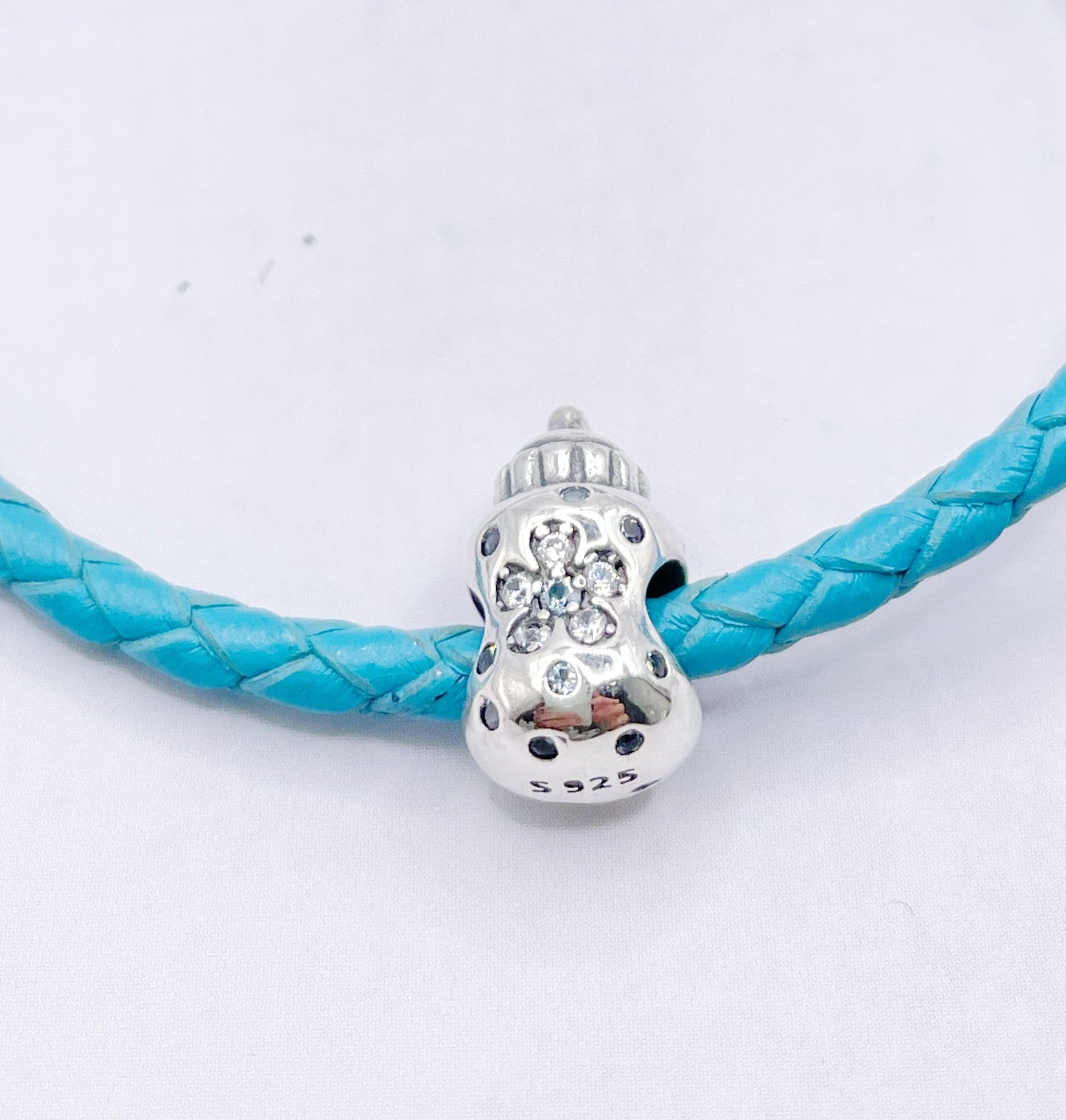 Charm Mamadera con flor y circonias blancas y celeste