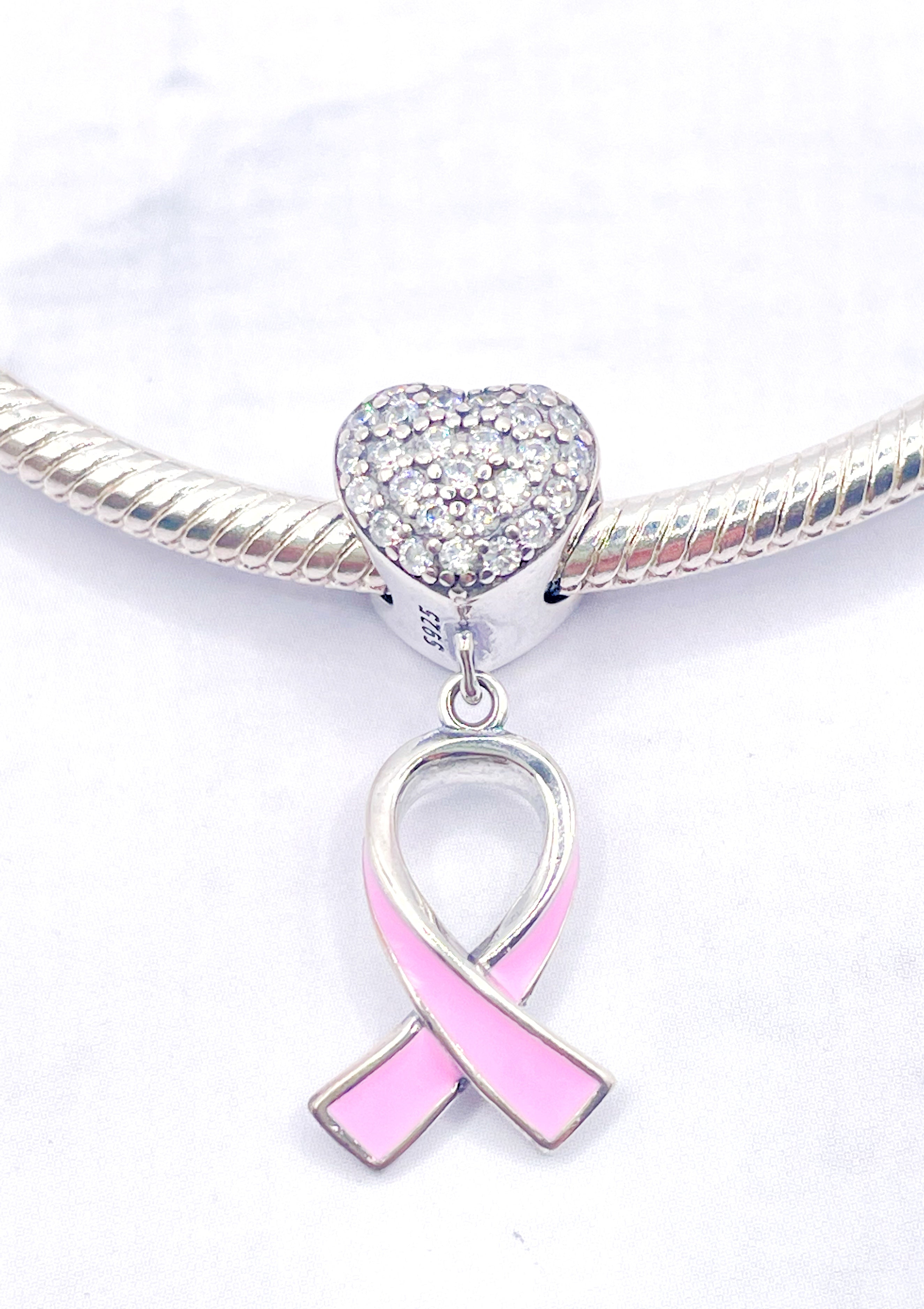 Corazón de circonias con lazo rosa